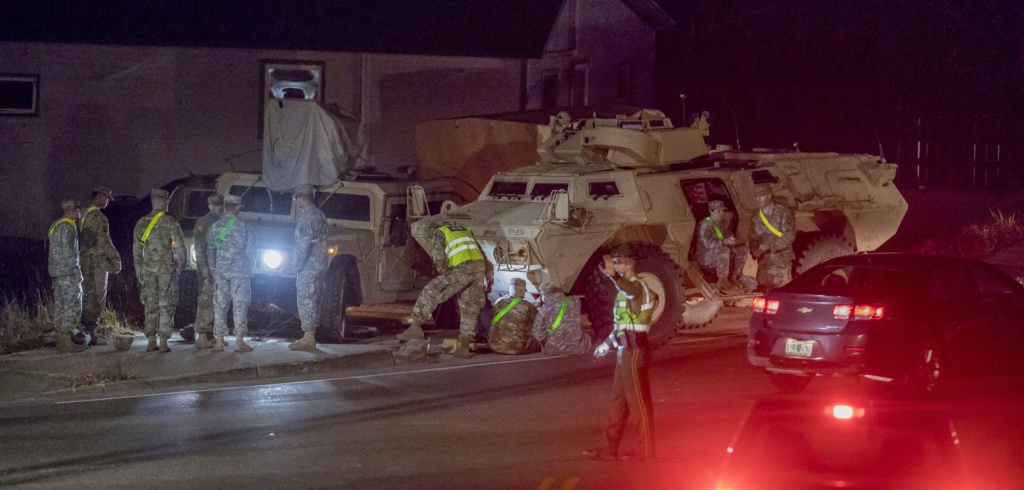 Soldiers work around an armored security vehicle on Main Street in Fairfax on Tuesday after a crash rendered the military vehicle inoperable.  A secondary crash caused by the backlog of traffic resulted in a civilian's DUI charge. Gregory J. Lamoureux