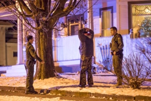Border Patrol Agents hold a man while Sheriff's Deputies search a home at 172 South Main Street in Richford on Sunday evening. Photograph By Gregory J. Lamoureux